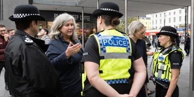Policewomen wearing high vis speaking to women