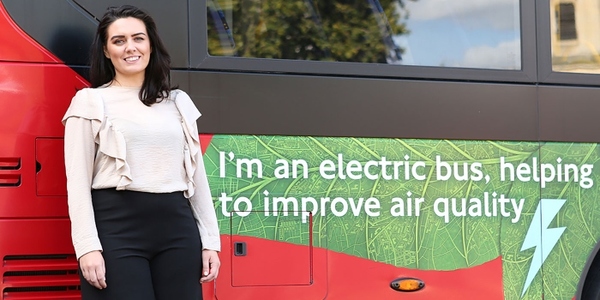 Woman standing in front of an electric bus