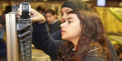 Young girl inspecting a piece of engineering kit