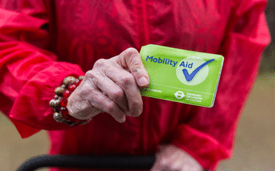 Photo of a person displaying their mobility aid recognition scheme card