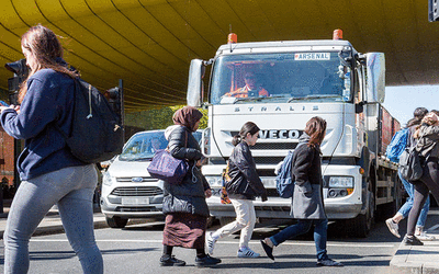 Intersection with pedestrians crossing safely in front of a heavy goods vehicle